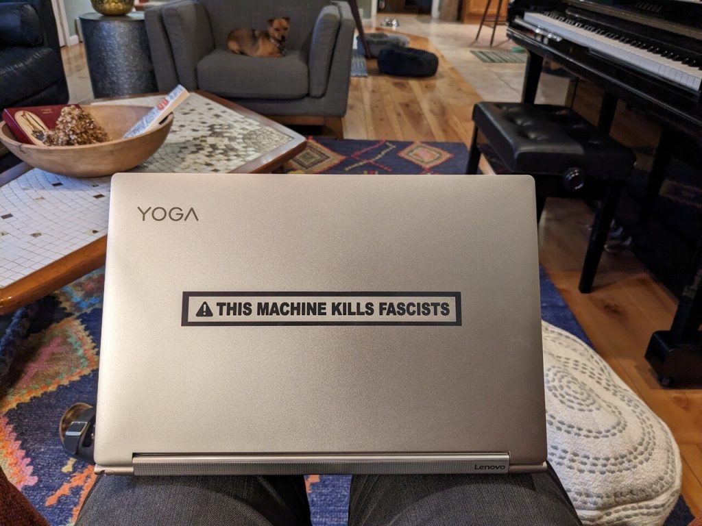 Lenovo laptop from the back with a \"This Machine Kills Fascists\" sticker